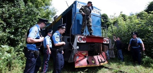 Ukrajinští policisté stráží chladírenský vlak, který přivezl těla obětí katastrofy boeingu.