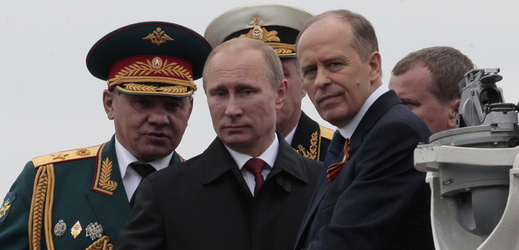 Ruský prezident Vladimir Putin, minist obrany Sergej Šojgu (vlevo) a ředitel FSB Alexandr Bortnikov, (vpravo).