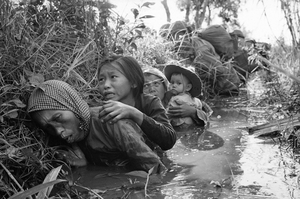 Vyděšení vesničané na jihu Vietnamu se ukrývají před střelbou.
