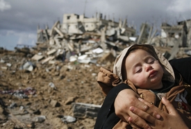 Palestinská žena, která drží v rukou své dítě, se nachází v Pásmu Gazy.