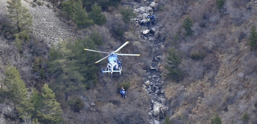 Záchranáři prohledávají místo pádu letadla.