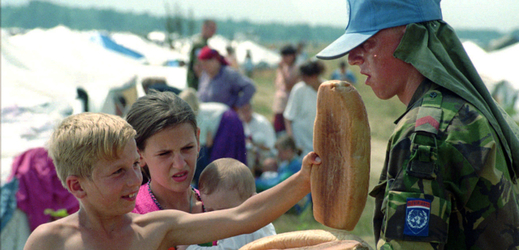 Uprchlíci ze Srebrenice. Nizozemští příslušníci UNPROFOR rozdávají chléb bosenským dětem na letišti v Tuzle. Červenec 1995.
